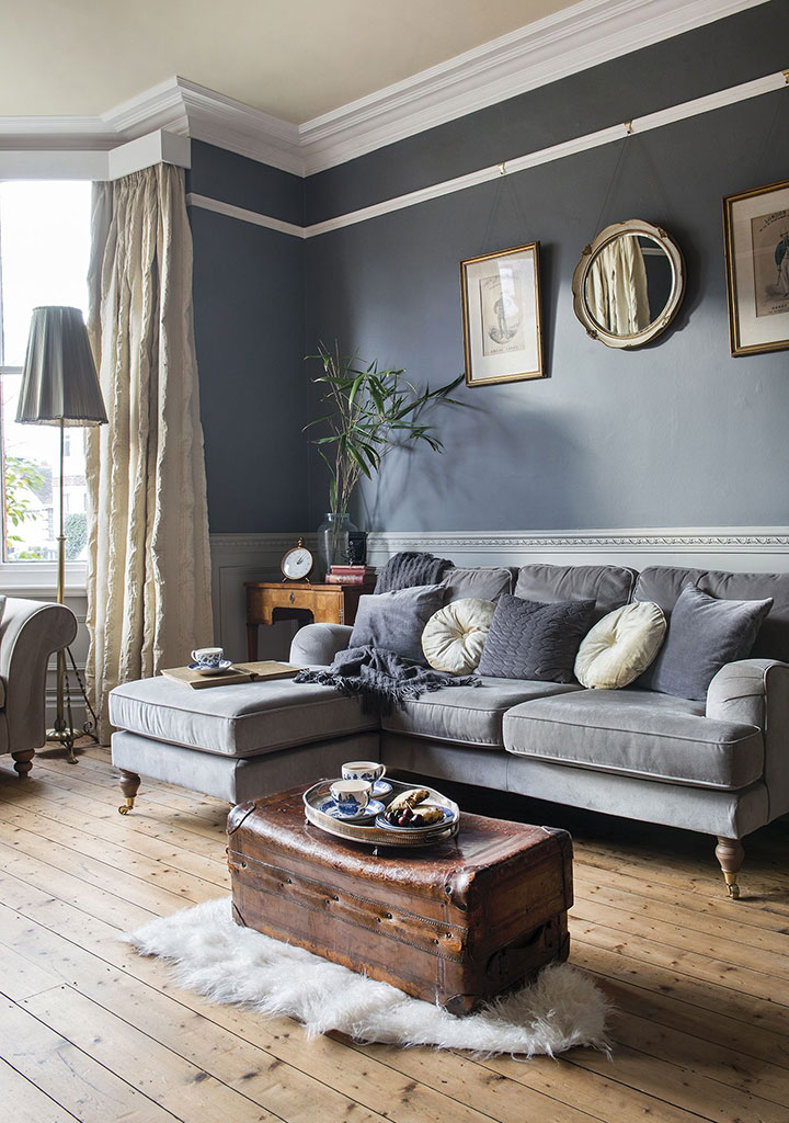 Salón gris clásico con suelo de madera, una alfombra peluda y cortinas