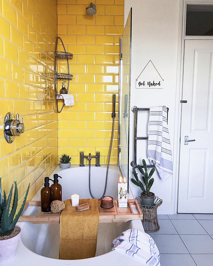 Baño amarillo con azulejos metro y cactus