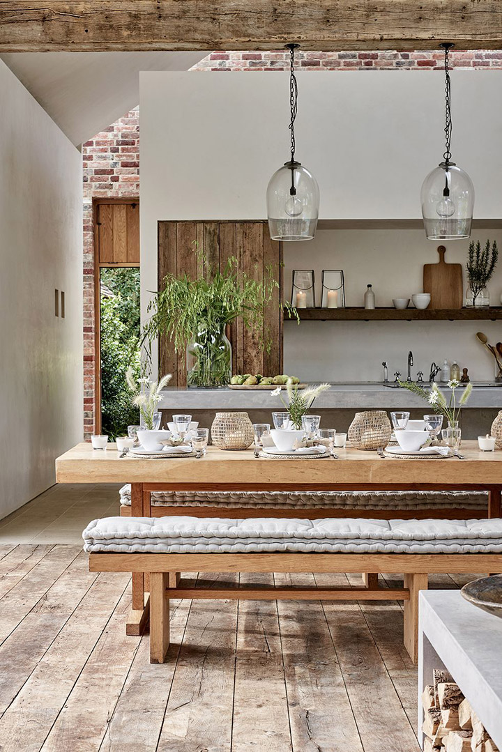 Cocina rústica de espacio abierto con piso de madera y paredes de ladrillo visto