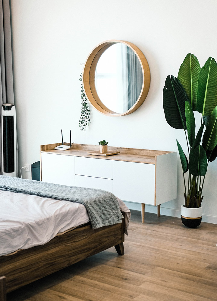 Dormitorio minimalista con un espejo y una planta
