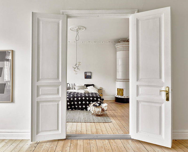Dormitorio estilo escandinavo con doble puerta de madera blanca