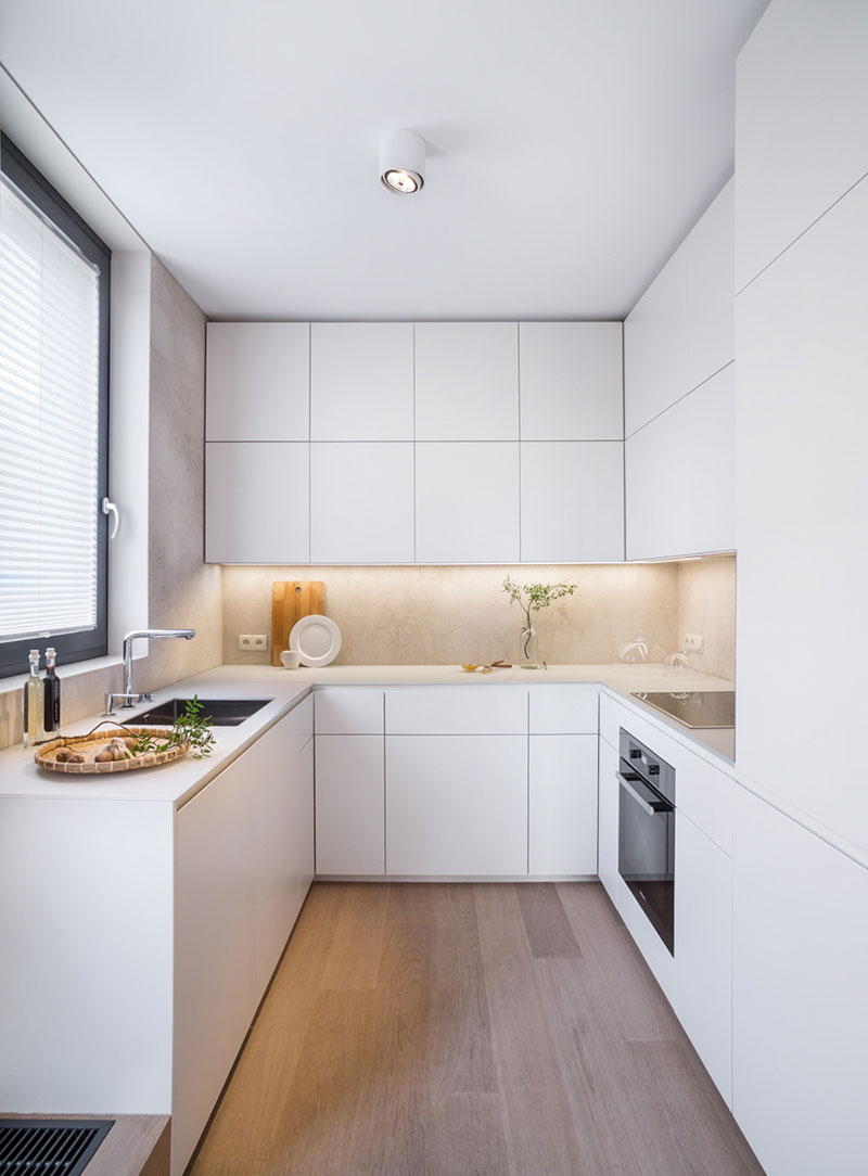 Cocina moderna blanca pequeña con armarios panelados