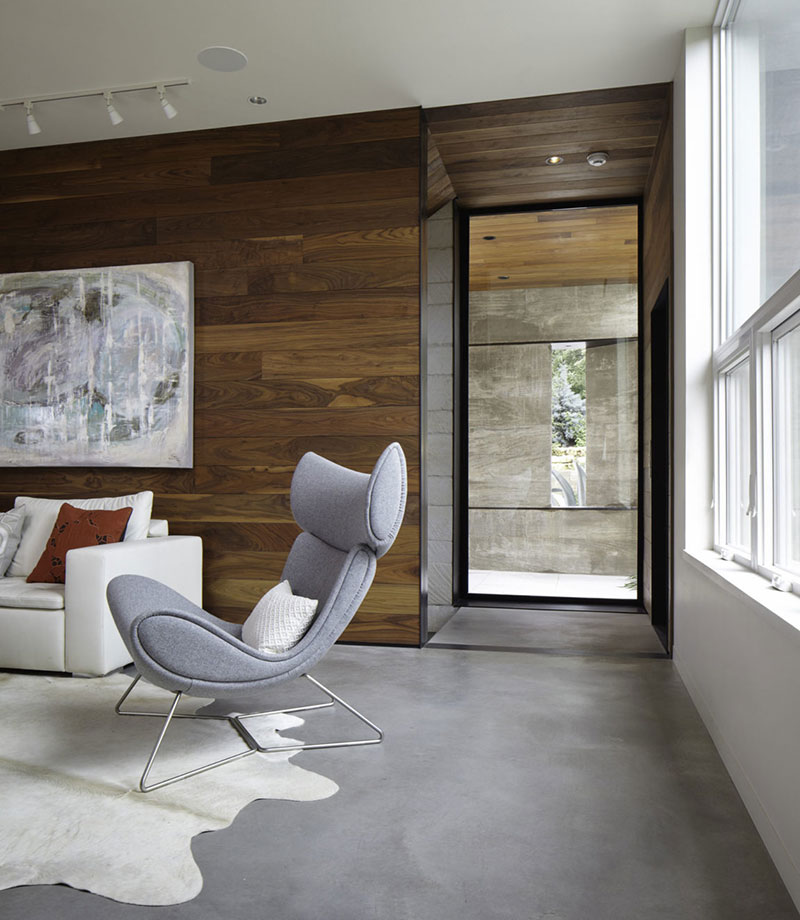 Salón estilo moderno con suelo de cemento pulido y paredes de madera