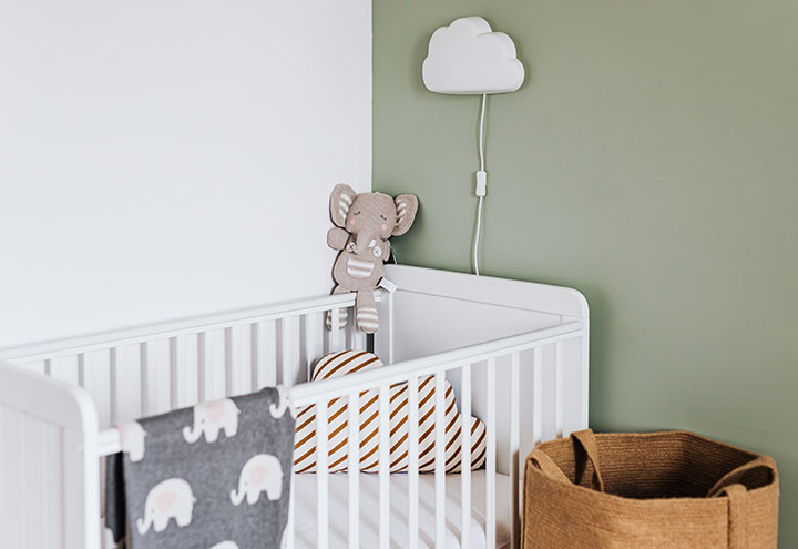 Dormitorio de bebé con cuna y cesto de la ropa