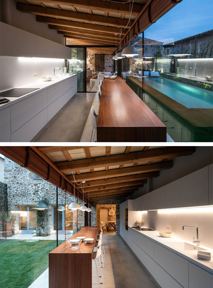 Una cocina con vistas a la piscina en esta masia remodelada en Gerona